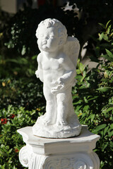 The white little cupid statue decorated in the garden