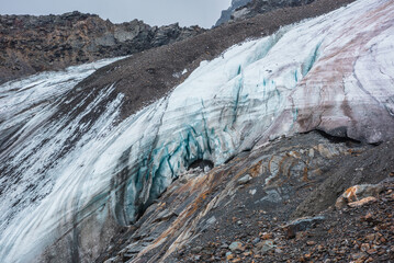 Awesome dramatic landscape with beautiful hanging glacier. Hole in dirty glacier near sharp...