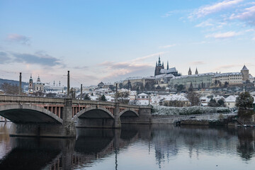 Fototapeta na wymiar First snow in Prague, Vltava river and Prague Castle in the early winter