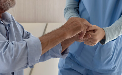 Close up elderly man holding caregiver in nursing home, Senior Care concept