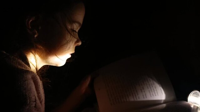 The girl is in the dark because of the lack of electricity. Child in the dark. War in Ukraine. Destruction of Ukrainian infrastructure. De-energized Ukrainian cities.Russian aggression against Ukraine