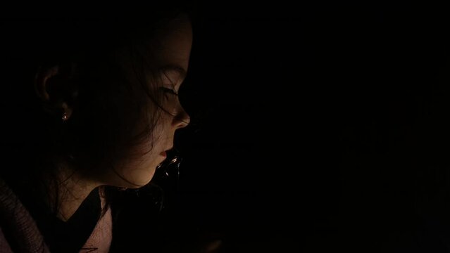 Child in the dark. The girl is in the dark because of the lack of electricity. War in Ukraine. Russian aggression against Ukraine. Destruction of Ukrainian infrastructure.De-energized Ukrainian cities
