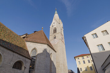 Fototapeta na wymiar Street and White Tower in Brixen, Italy