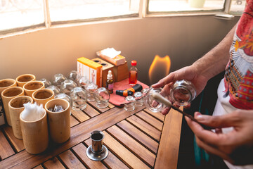 Traditional chinese medicine doctor sterilizing tools with alcohol and fire in a wood table with...