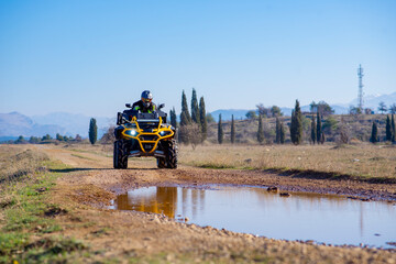 Fototapeta premium Girl driving ATV on dirt road