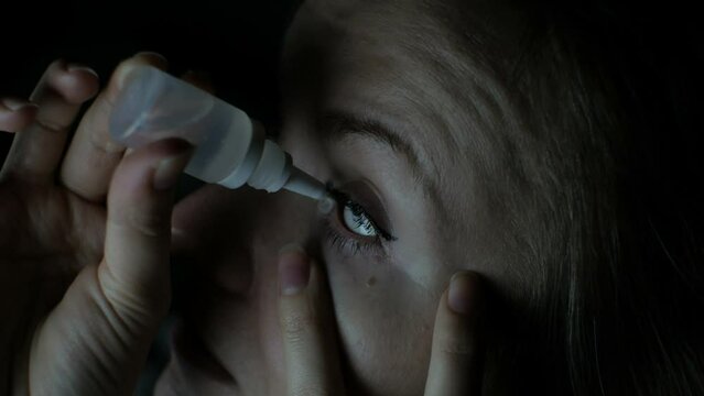Woman is putting drops in his eyes. Medical treatment concept. Allergic conjunctivitis problem. Works on internet in front of computer all day. Eye pain, dry eye syndrome.