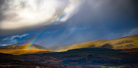 Rainbow and storm clouds across a Welsh mountain landsape
