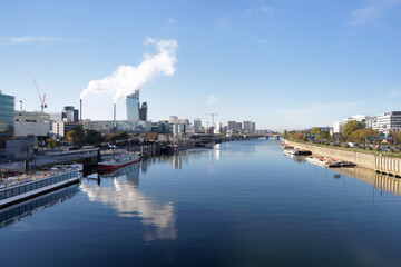 Fototapeta premium Incinerator chimneys and Seine river in Paris suburb. Ivry-sur-Seine city