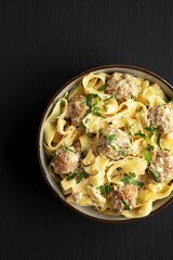 Homemade One-Pot Swedish Meatball Pasta in a Bowl on a black background, top view. Flat lay, overhead, from above. Copy space.