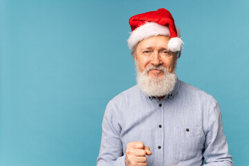 Happy confident cool old bearded Santa Claus winner raising fist celebrating triumph and success...