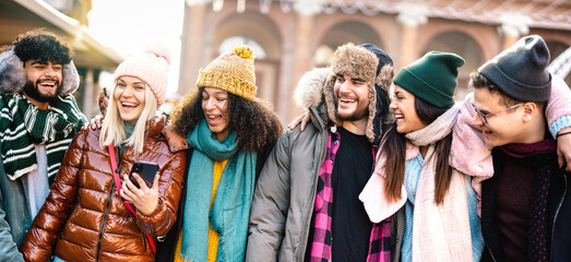 Happy students group walking at european city on sunny day - Lifestyle concept with multiracial young people wearing winter clothes having fun together