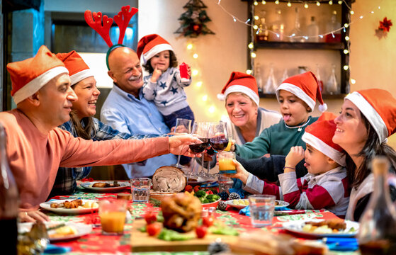 Happy family toasting at christmas supper fest - Winter holidays xmas concept with grand parents and children eating together at home party reunion
