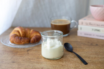 Delicious breakfast consisting of a yogurt, a croissant and a coffee. Slow morning concept