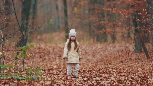 little girl running through the autumn forest