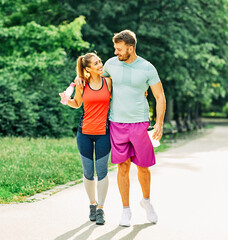 fitness woman park exercise lifestyle outdoor sport healthy couple nature active young fit fun love partner two talking