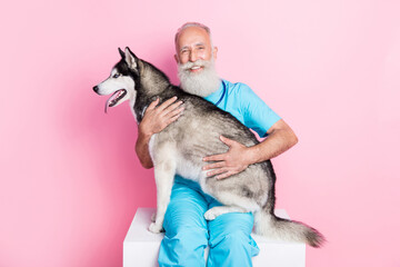 Photo of professional vet man hold big fluffy alaskan malamute examine shelter doggy isolated on...