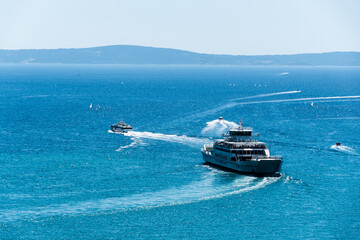 View with a ferry boat from the Jadrolinija company on the Adriatic sea, windsurfers and small boats. Split, Croatia.