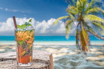 cocktail on the beach with blue sky and palm tree in the background