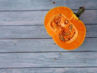 Half of an orange pumpkin on a blue wooden background. Top view