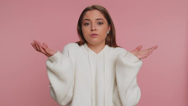 I dont know what to say. Confused woman feeling embarrassed about ambiguous question, having doubts, no idea, being clueless and uncertain. Young girl isolated alone on pink studio wall background