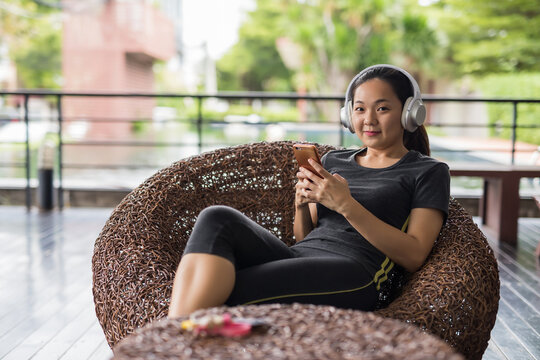 Sporty Asian young woman using smartphone after workout break