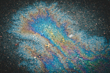 Leaked petroleum products on the roadway. Abstract rainbow background