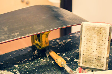 Ski repair shop employee workman melts drops red wax on snowboard with special wax iron. Ski...