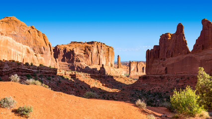 Fototapeta premium Sunny Picturesque Desert Rock Valley, Natural Monument Avenue Viewpoint and Courthouse Towers at Arches National Park, Utah, USA