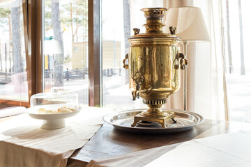 Traditional Russian samovar on table. Space for text.Metal samovar on grey table in kitchen....