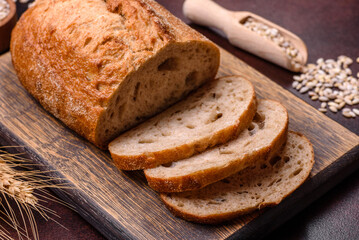 A loaf of brown bread with grains of cereals on a wooden cutting board