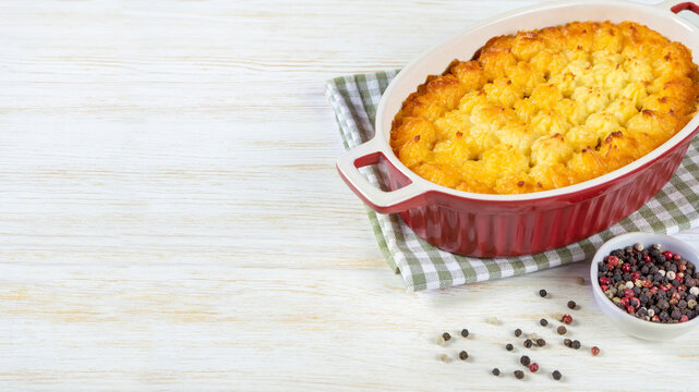 Shepherd's pie or Cottage pie. Minced meat, mashed potatoes and vegetables casserole on white wooden background with copy space for text. Traditonal British, United Kingdom, Ireland cuisine