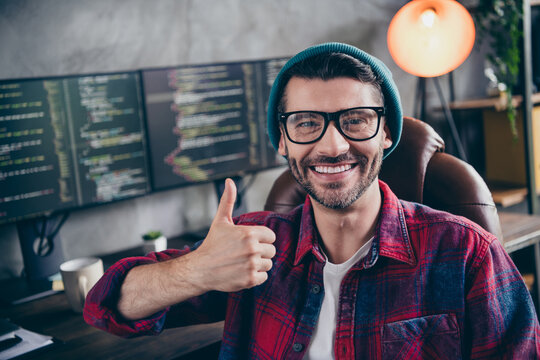 Photo of smiling cheerful guy dressed eyewear showing thumb up rating work indoors workstation workshop home