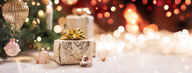 Christmas gifts with bright illumination lights on a light wooden background near a fireplace with...