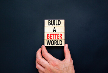 Build a better world symbol. Concept words Build a better world on wooden cubes. Beautiful black table black background. Businessman hand. Business build a better world concept. Copy space.