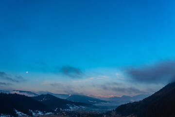 Mountain atmospheric landscape of high mountains in thick fog in rainy weather, panorama of mountain tops in thick clouds.