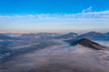 Carpathian peaks in the morning in the clouds, top view, drone footage.
