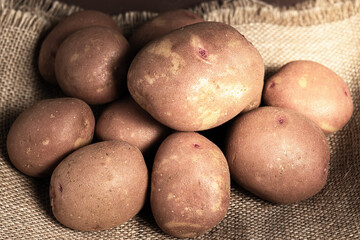 CLOSED UP OF A SET OF POTATOES ON A BAG AND A BROWN BACKGROUND
