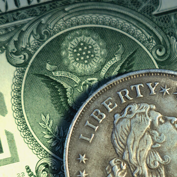 Close up one Dollar bill and coin with description: Liberty as symbol: America - the land of opportunities and freedom.