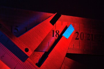 caliper and metal rulers illuminated in red and blue. close-up