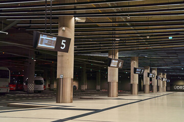 An empty bus station inside with parked buses and large columns. High quality photo