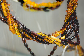 Various amber beads on a glass shelf