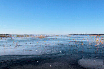 Lake partially covered with ice on a, early spring sunny day