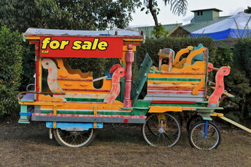 Multicolored carriage for riding children put up for sale. Yungaburra-Australia-273 - Powered by Adobe