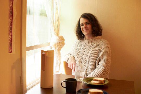 Portrait of transgender woman sitting by window
