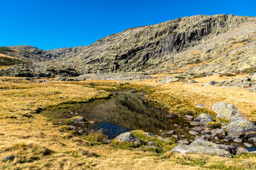Fototapeta premium Beautiful landscape of rocks on a meadow in Gredos Park in Spain under a blue sky during autumn