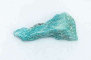 Natural amazonite gemstone isolated on white background. A bluish-green crystal on a white...