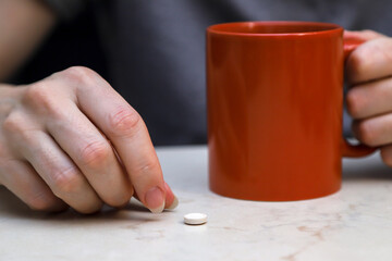The middle-aged woman taking a pill