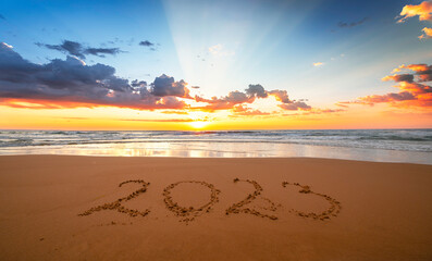 Beautiful sunset with 2023! Happy new year 2023 concept! Year 2023 written in the sand on the beach...