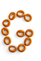 Letter G bagel. Bagels font. Alphabet from set of small dry bagels isolated on white background. ABC symbols.
