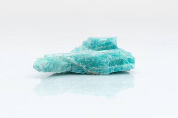 Natural amazonite gemstone isolated on white background. A bluish-green crystal on a white...